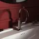 Waschtischarmatur von Ideal Standard mit schlichten Kreuzgriffen in Chrom. Eingebaut auf ein weißes Waschbecken, vor roten Wänden.
